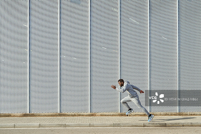 奔跑在城市荒凉街道上的健壮男人图片素材