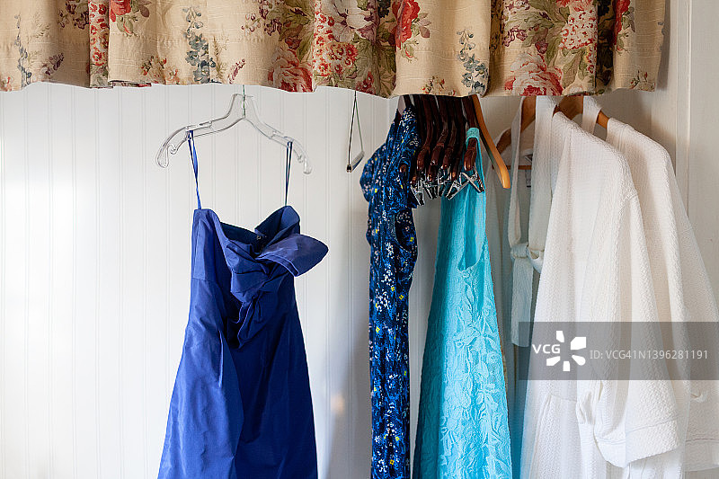 壁橱里的三件蓝色连衣裙和两件白色长袍图片素材
