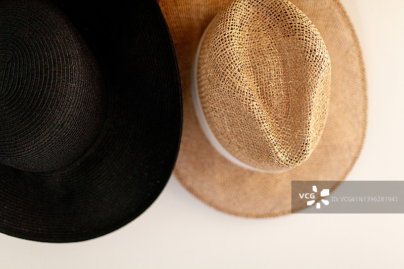 挂在白色墙上的两顶草帽特写图片素材
