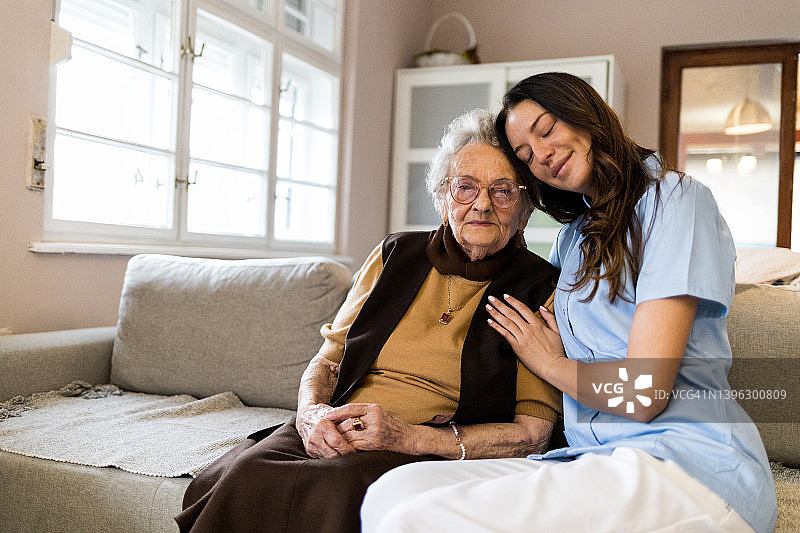 年轻医护人员家访时拥抱年长患者图片素材