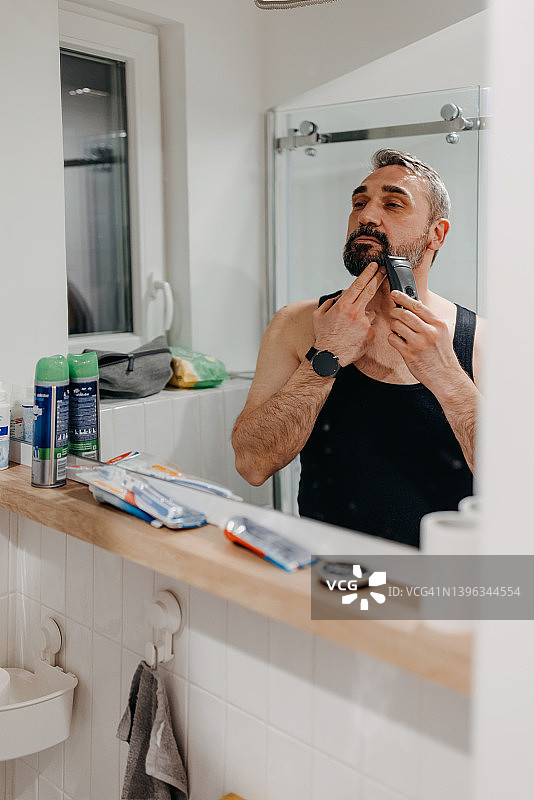 在浴室刮胡子的成熟男人图片素材