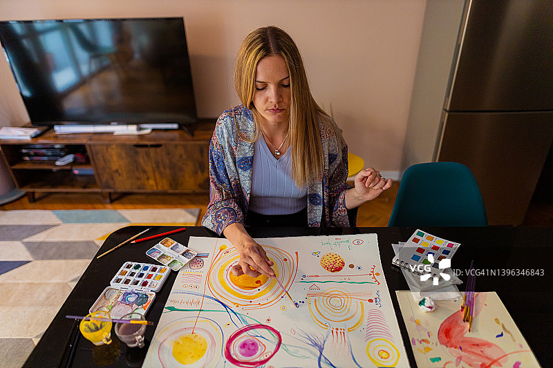 在画作上添加细节的女艺术家图片素材