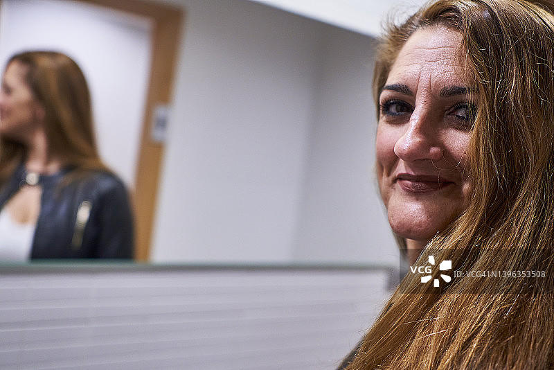 在室内浴室里对着镜头微笑的快乐中年妇女肖像图片素材