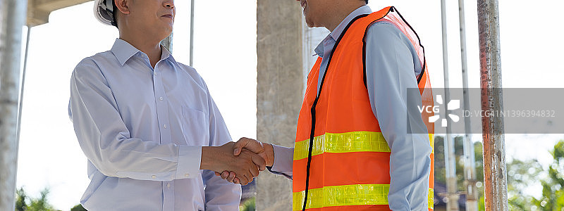 握手，建筑工地施工成功。图片素材