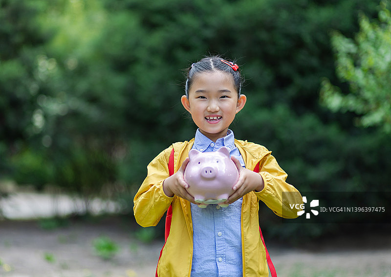 拿着储蓄罐的亚洲小女孩图片素材