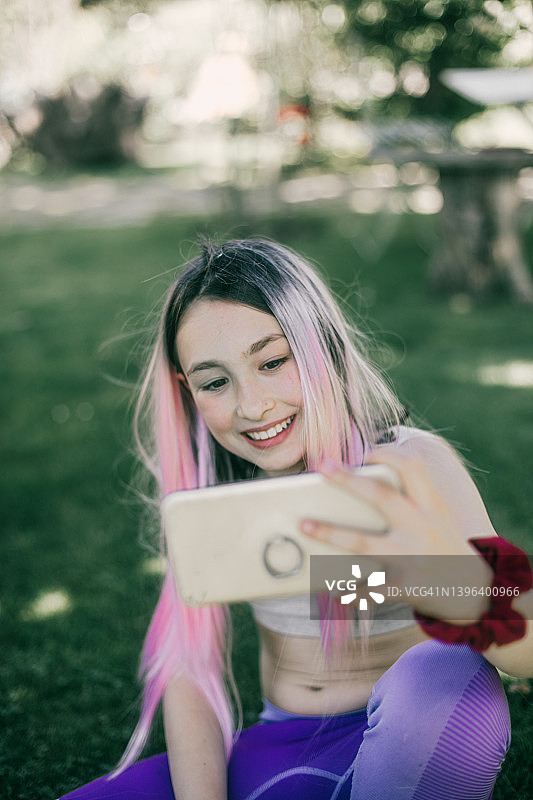 女孩用手机自拍，伸出舌头图片素材