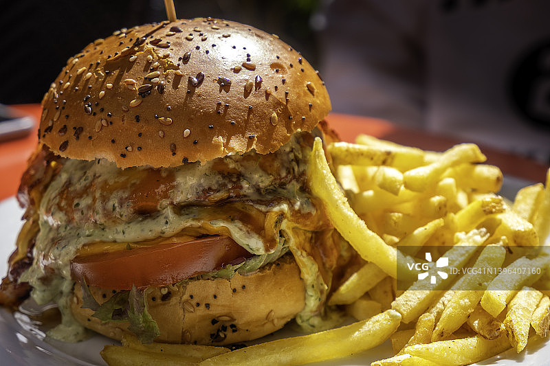 阳光下盘中全料芝士汉堡配薯条图片素材