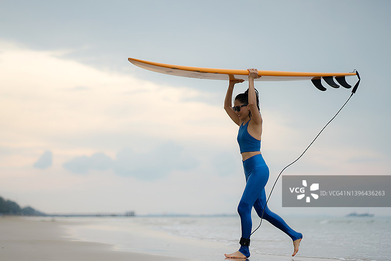 亚洲女人在海滩上享受冲浪图片素材