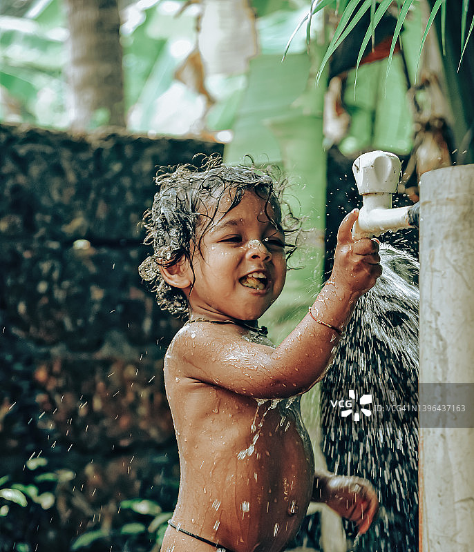在自来水下洗澡的小男孩图片素材