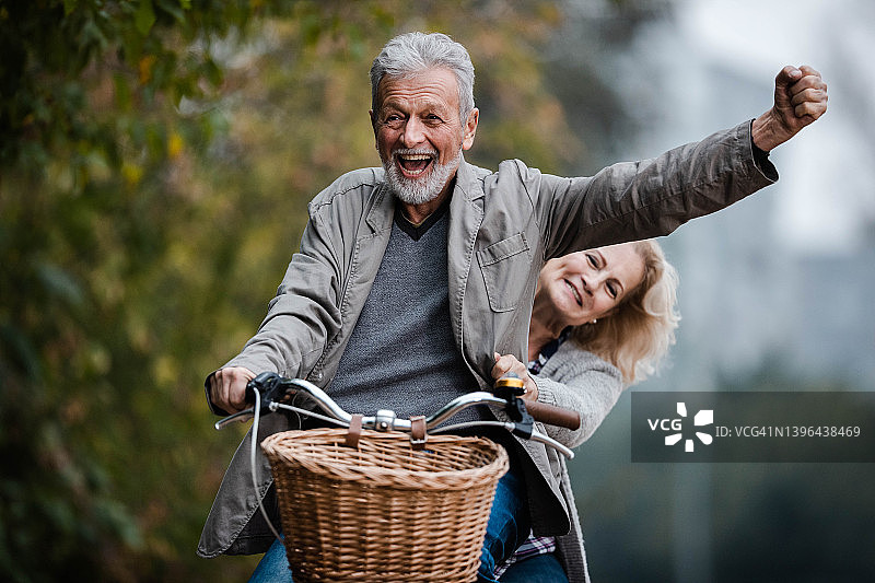 在秋日骑自行车玩耍的老年夫妇图片素材