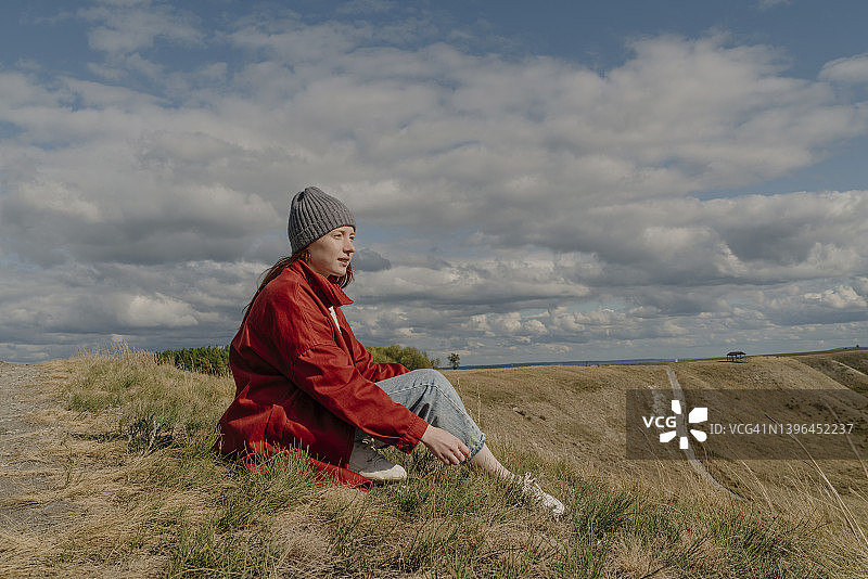 周末坐在田野里的年轻女人图片素材