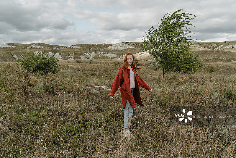 年轻女人在草地上旋转。图片素材