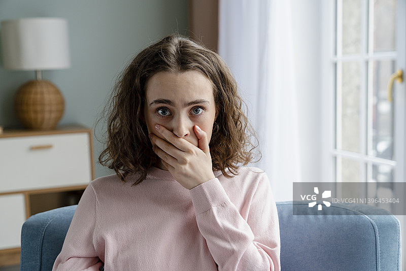年轻女子在家捂嘴图片素材