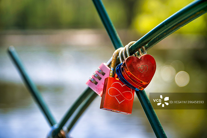 湖泊背景下围栏上的爱情锁图片素材