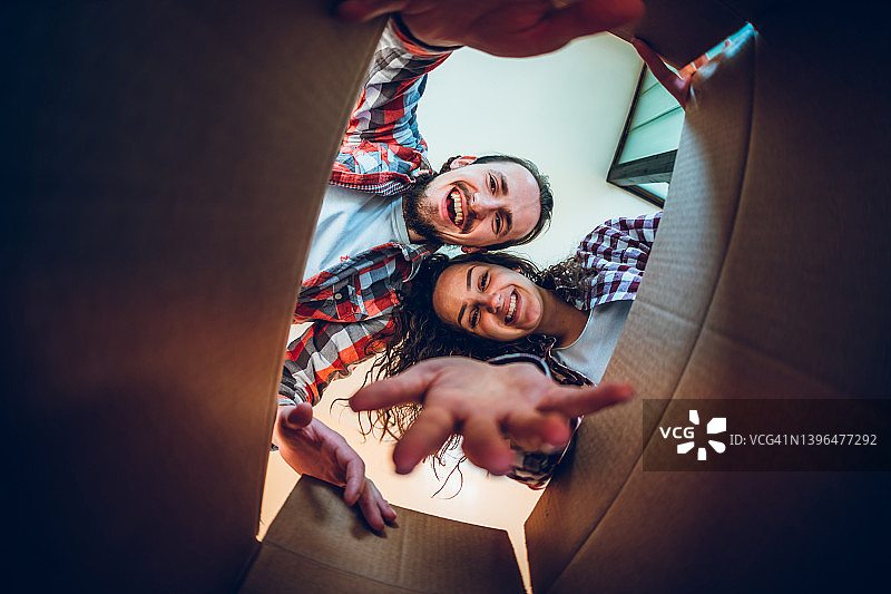 快乐的年轻夫妇正在看盒子里面图片素材