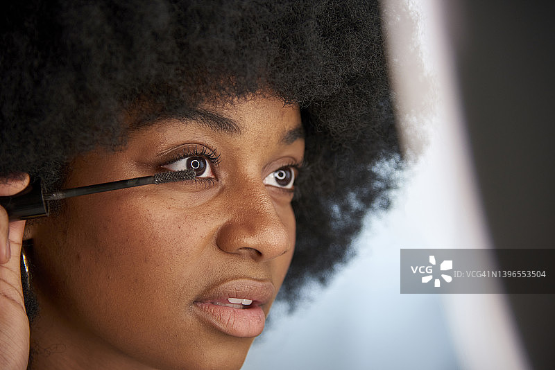 非洲裔女人在化妆时给睫毛涂睫毛膏图片素材