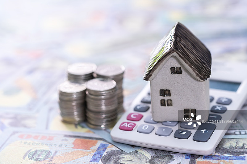 计算器上的房子与硬币：购房储蓄计划图片素材