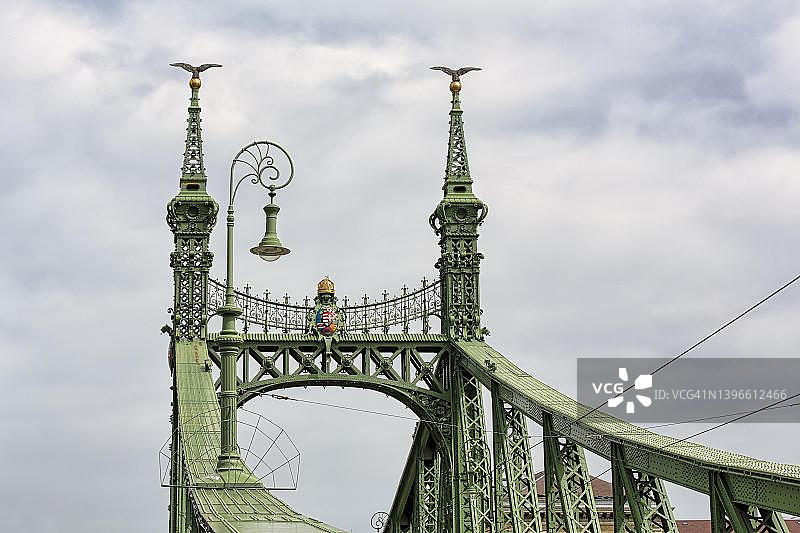 匈牙利布达佩斯自由桥上的华丽桥门和灯笼，带有神话生物图鲁尔的两座塔图片素材