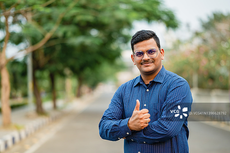 年轻印度男人竖起大拇指微笑着庆祝成功图片素材