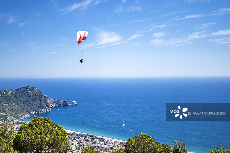 快乐的男子在双人滑翔伞飞行中翱翔图片素材