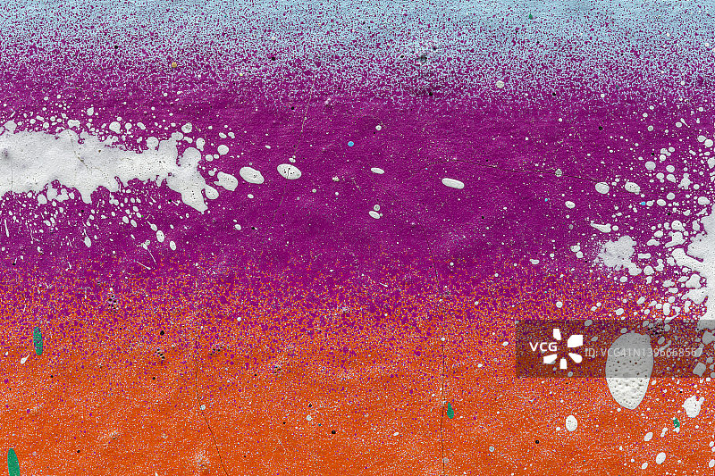 喷涂有紫色、橙色和浅蓝色或蓝绿色油漆的墙壁的微距特写图片素材