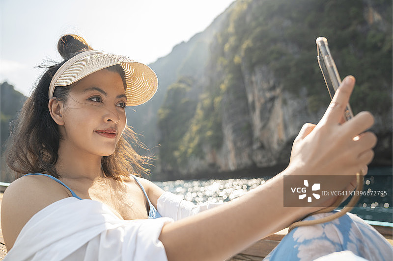 亚洲女性在泰国普吉府皮皮岛与游船自拍图片素材