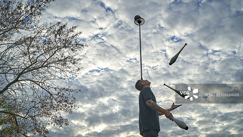 街头艺人在公园玩抛杆杂耍图片素材