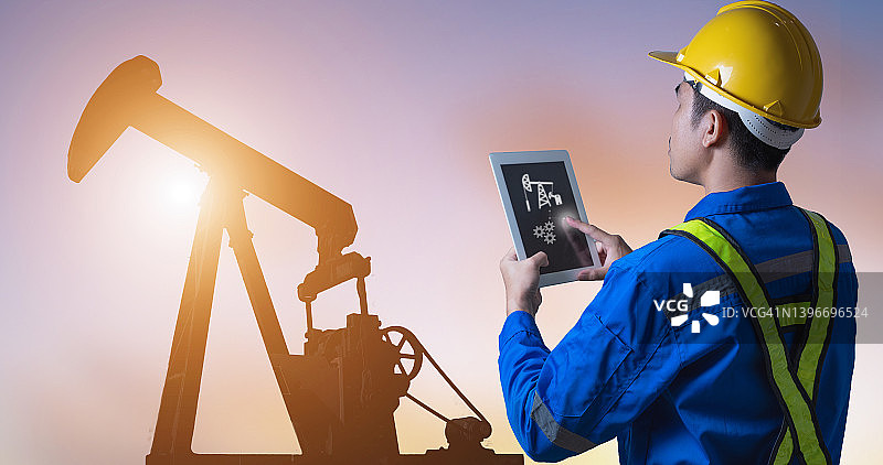 油井或油田抽油机轮廓和工人，勘探、石油和天然气工业，背景为油泵的工程师与笔记本电脑，软件和数字化制造运营，新兴产业图片素材