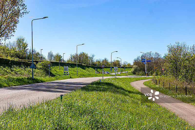 乡间小路和自行车道之间的绿草地图片素材