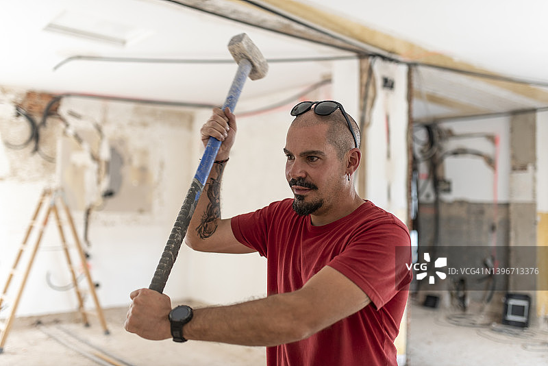 建筑工人在房屋改造中使用破拆锤图片素材
