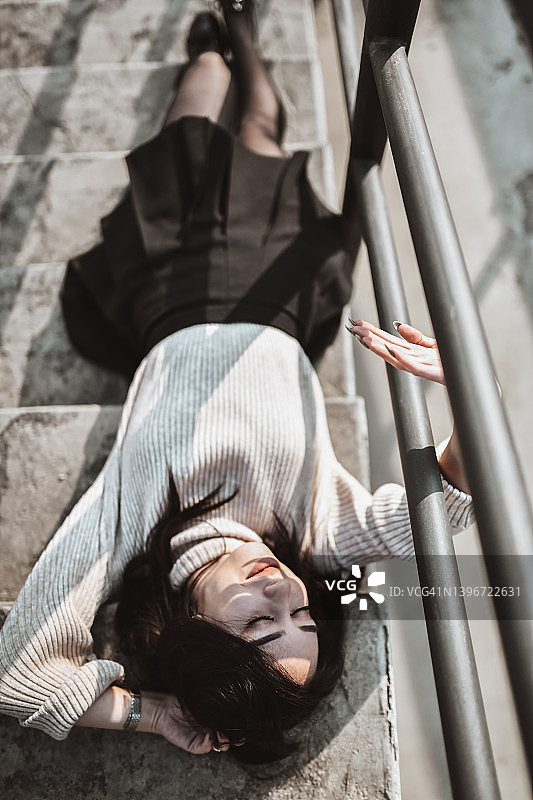 女人在室外楼梯上小憩图片素材