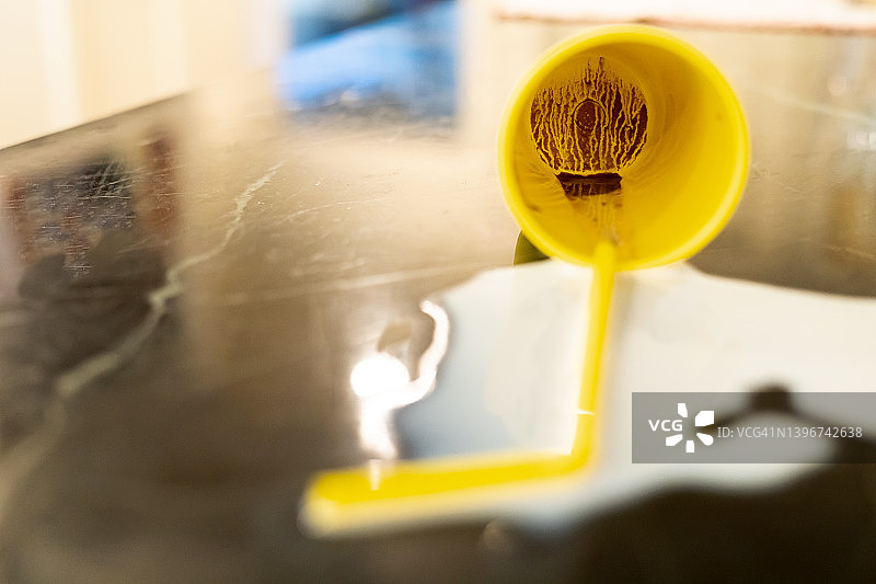 不要为打翻的牛奶哭泣：明亮的黄色杯子和吸管被打翻在柜台上，牛奶溅了出来（杯子底部有巧克力）图片素材