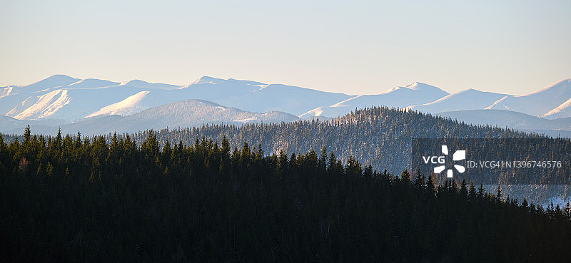 白雪皑皑的山峰和树木繁茂的山谷全景图片素材