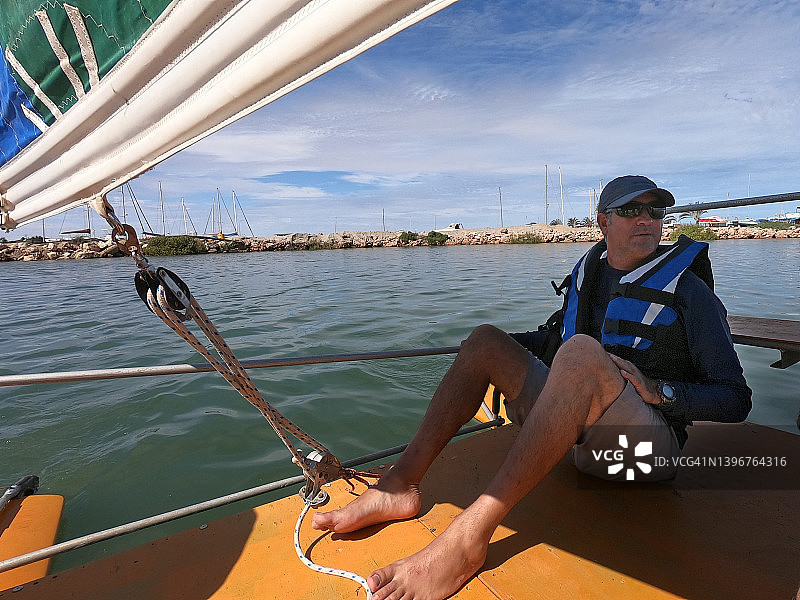 驾驶双体船的澳大利亚中年男子图片素材