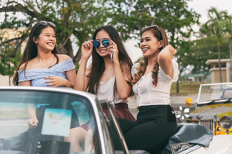 在敞篷车里的快乐亚洲女性图片素材