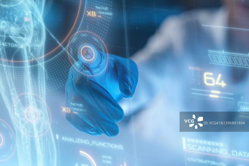 戴着防护手套的手使用HUD或图形显示全息图的特写图片素材