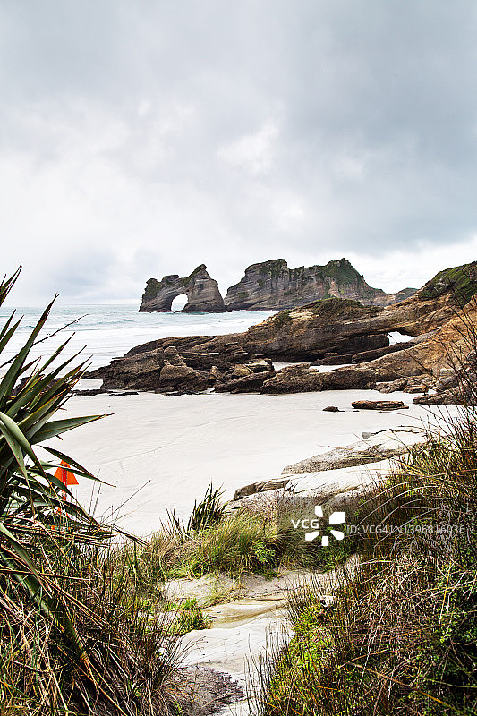 新西兰黄金湾瓦拉里基海滩拱门岛和岩石海岸线的柔和阴郁海景图片素材
