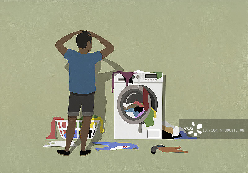 沮丧的男人看着堆在洗衣机上的衣服图片素材