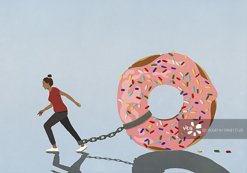 用链子拴在试图行走的女人腿上的大甜甜圈图片素材