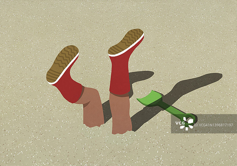 穿着橡胶靴埋在阳光明媚的沙滩上的腿图片素材