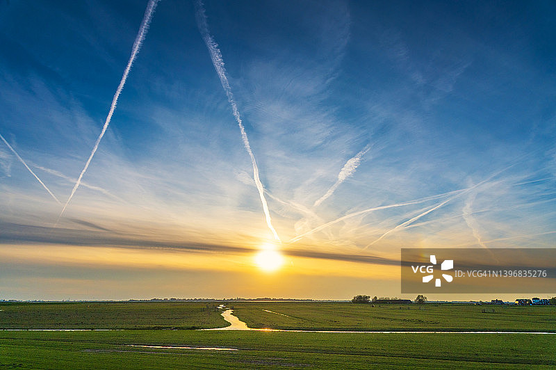 农业平原上的日落、尾迹和云彩图片素材