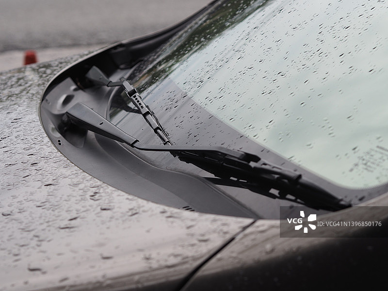 雨季：雨水落在玻璃上，雨滴落在汽车挡风玻璃上图片素材