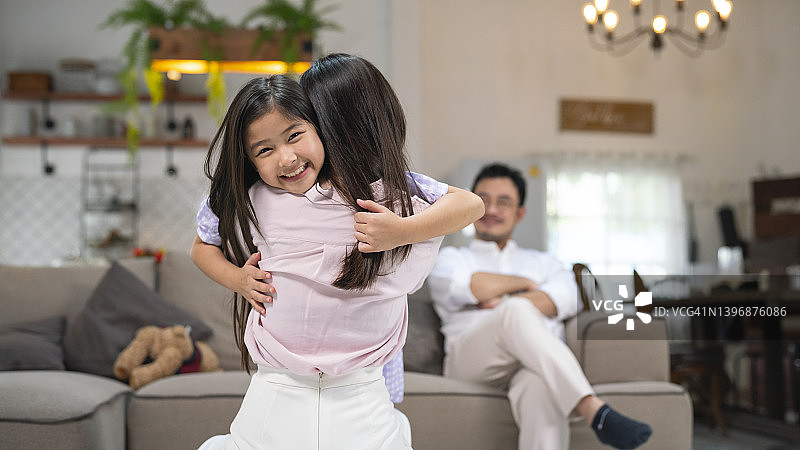 在客厅里，女儿拥抱她的母亲图片素材