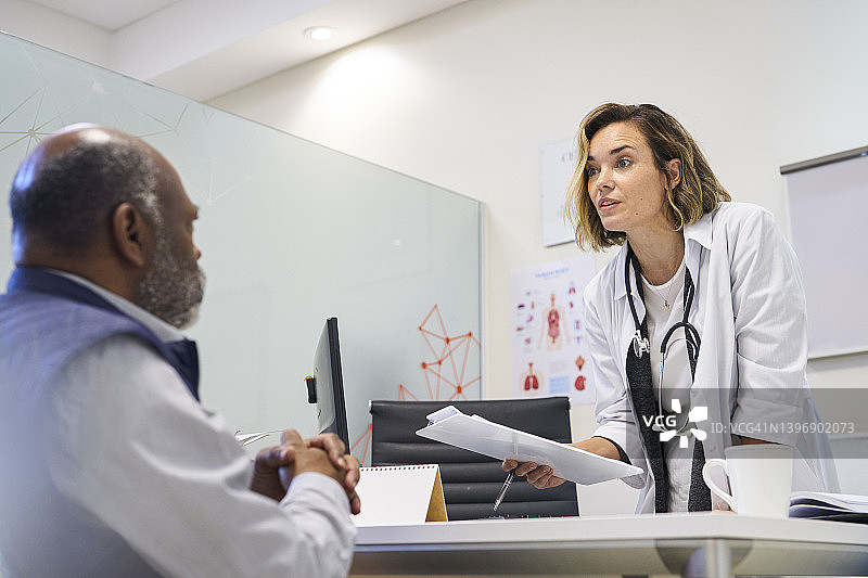 白人女医生与病人交谈并拿着处方单图片素材