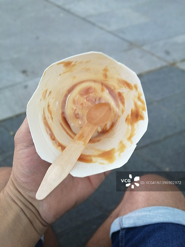 无法辨认的人手中拿着空的冰淇淋容器图片素材