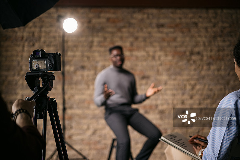 记者在演播室采访一位英俊的年轻人图片素材