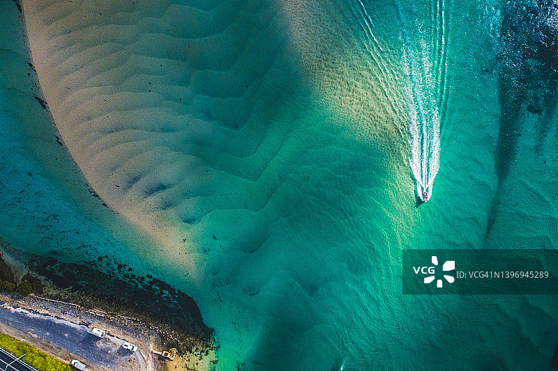 海岸边在翠绿色海水中航行的单只船图片素材