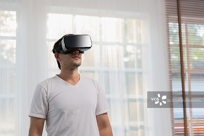 男人在家戴虚拟现实头显或VR眼镜图片素材