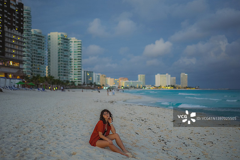 坐在坎昆酒店区海滩上的女人图片素材