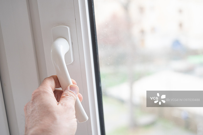 一人打开或关闭窗户，注意隔热和节能图片素材